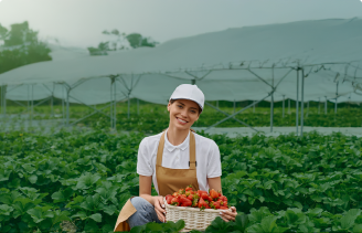 Mujer agricultora sosteniendo una canasta de tomates